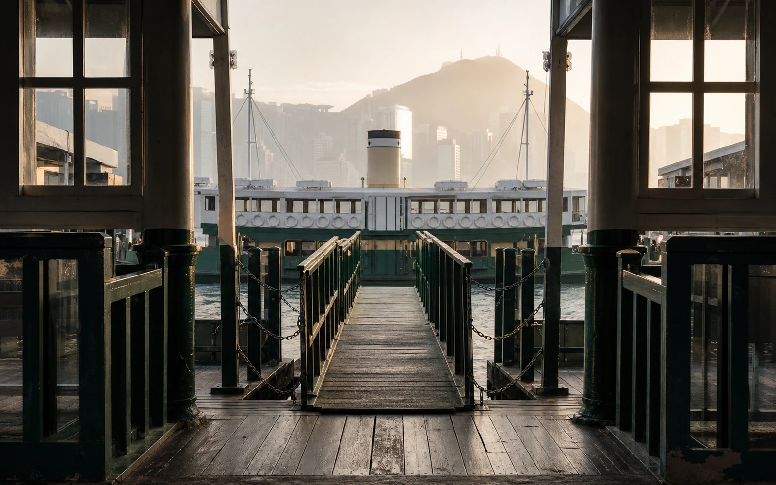 Gangway am Star-Ferry-Pier mit grüner Reling, dahinter die Fähre im Morgenlicht